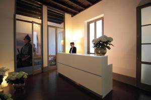 a woman standing in a room with a counter with flowers at Antica Locanda Dei Mercanti in Milan