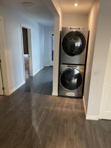 Dos lavadoras y secadoras apiladas en una sala de estar en Apt Milieu, en Gatineau 9 fotos más