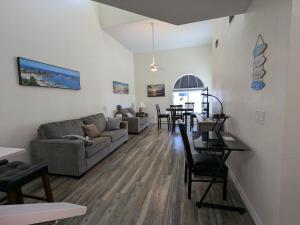 卡纳维拉尔角Oceanfront 2br2b, Ocean Views, Heated Pool, Spa的客厅里有一张沙发和一张桌子。