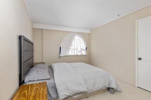 une chambre blanche avec un lit et une fenêtre dans l'établissement Comfortable and quiet bedroom with private bathroom, à Delta
