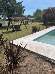a picnic area with a picnic table and a wooden picnic table next to a pool at Quinta El Oasis Junin in Junín