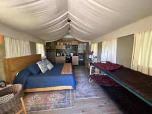 a bedroom with a large bed and a kitchen at Premium Lakefront Cabin 4 The Cardinal in Bastrop