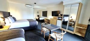 a hotel room with a bed and a desk and a room at Hotel Forster in Forster
