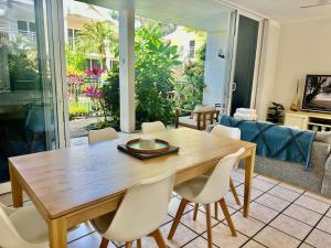 een eetkamer met een houten tafel en stoelen bij 3 Yaringa in Port Douglas