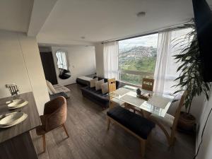 a living room with a table and a large window at Simplemente en Casa! in Manizales