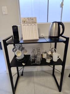 a black shelf with cups and utensils on it at Pousada do Centro in São Gabriel
