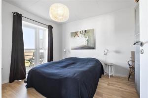 a bedroom with a bed with a blue blanket on it at HA259-Hals-Portlandsvej-97-B-1-mf in Hals