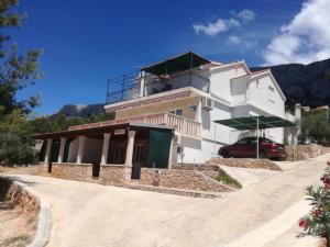 a building with a car parked in front of it at Classic One Bedroom Apartment with Terrace and Sea view in Sveta Nedelja
