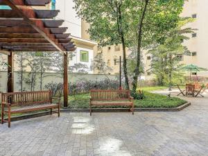 Deux bancs dans un parc avec un bâtiment en arrière-plan dans l'établissement Mercure Sao Paulo Alamedas, à São Paulo