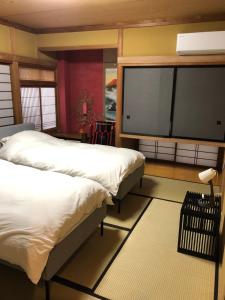 Un dormitorio con dos camas y un televisor de pantalla plana. en T'S House Numazu, en Numazu 70 fotos más
