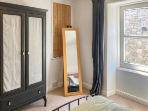 a bedroom with a black cabinet and a mirror at Nautilus in St Ives