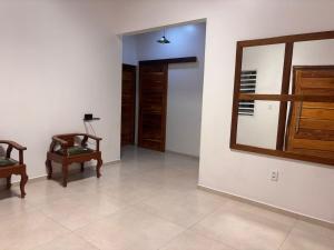 a living room with two chairs and a mirror at Cantinho Aconchegante in Macapá +4 photos