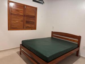 a bed in a room with a wooden cabinet at Cantinho Aconchegante in Macapá