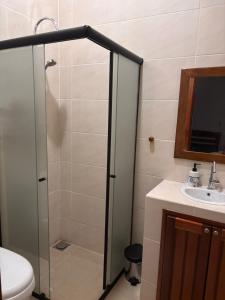 a bathroom with a shower and a toilet and a sink at Cantinho Aconchegante in Macapá