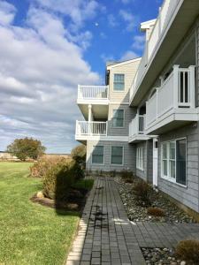 a white building with a balcony and a yard at No Chris in Waretown
