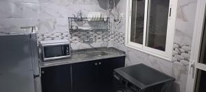 a small kitchen with a sink and a microwave at Appartement azrou in Azrou