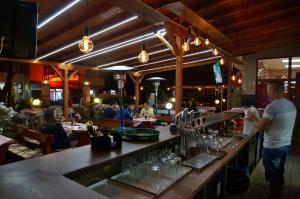 a man standing at a bar in a restaurant at Ryor Hotel - Restaurant & Free Parking in Sunny Beach