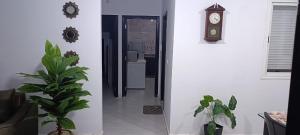 a hallway with a clock and a potted plant at Appartement azrou in Azrou +1 photo
