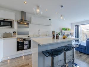 a kitchen with a counter and two stools in it at Nursery Mews in Whitstable