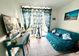 a living room with a blue couch and a table at Studio Ti Saphir in Le Diamant