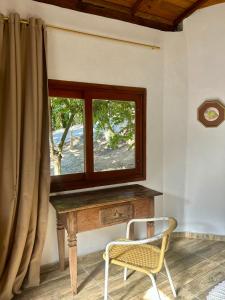 uma janela num quarto com uma mesa e uma cadeira em Loft 95m Sea - Private - condominium em Ilhabela