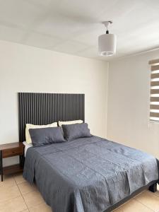 a bedroom with a large bed with a blue blanket at Casa con Jacuzzi cerca de Distrito 1 in Chihuahua