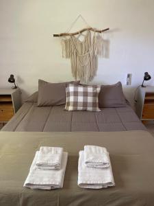a bedroom with a bed with two towels on it at Las Quimeras in Nono +42 photos