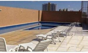 a group of chairs sitting on top of a swimming pool at Apartamento 2 quartos COP 30 in Belém