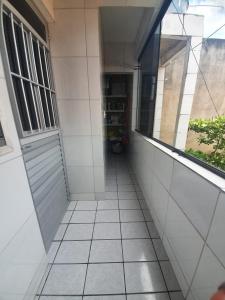 an empty hallway with a window and a tiled floor at Casa de praia inteira pé na areia Maragogi in Maragogi
