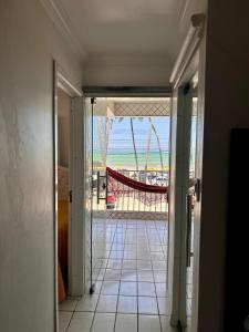 an open door to a balcony with a view of the beach at Casa de praia inteira pé na areia Maragogi in Maragogi