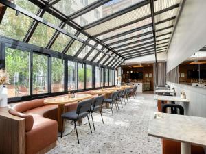 a restaurant with tables and chairs and windows at Mercure Paris 15 Porte de Versailles in Paris