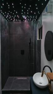 a bathroom with a sink and a shower with lights at New Apartment Santa Fe in General Luna