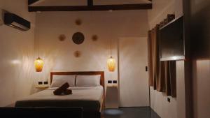a bedroom with a bed and two lights on the wall at New Apartment Santa Fe in General Luna