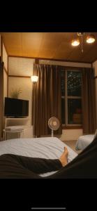 a person laying on a bed in a bedroom at One room Pusang Gala Yuki City in Yuki