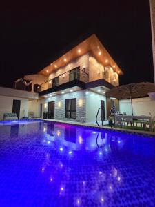 a swimming pool in front of a house at night at C Urban Villas - Modern Luxury Home in Pampanga in Dau