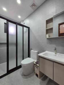 a bathroom with a toilet and a sink at C Urban Villas - Modern Luxury Home in Pampanga in Dau