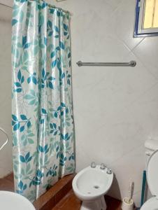 a bathroom with a shower curtain and a toilet at Alojamiento la posta in Perico +27 photos