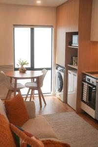 een woonkamer met een tafel en een keuken bij The Urban Nest in Wellington