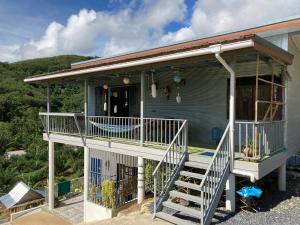 ein blaues Haus mit einer Veranda und einer Treppe in der Unterkunft Stylish Bohemian Getaway with Breathtaking Sea Views in Ko Lanta