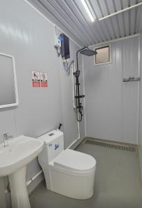 a bathroom with a white toilet and a sink at Banana Bar in San Juan