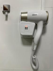 a telephone hanging on a wall in a bathroom at Casa em Içara Prox Criciúma in Içara