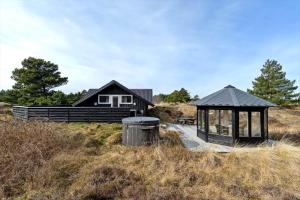 ein Haus mit einem Pavillon inmitten eines Feldes in der Unterkunft 0206 Rømø - P S Carlsvej 22 in Tagholm