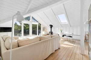 ein weißes Wohnzimmer mit einer Couch und einem Tisch in der Unterkunft 0206 Rømø - P S Carlsvej 22 in Tagholm