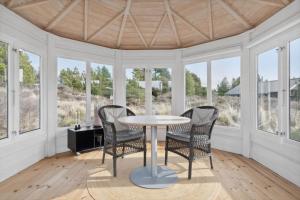 ein Esszimmer mit Tisch und Stühlen und Fenstern in der Unterkunft 0206 Rømø - P S Carlsvej 22 in Tagholm + 17 Fotos