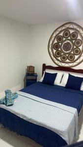 a bedroom with a bed with blue sheets and a basket at Suíte Mykonos Canoa Quebrada- Ao lado da Broadway in Aracati