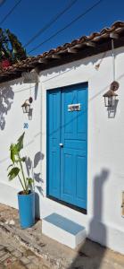a blue door on a white building with a plant at Suíte Mykonos Canoa Quebrada- Ao lado da Broadway in Aracati +7 photos