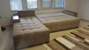 a large tufted bed in a living room at 4U Apartment in Burgas City