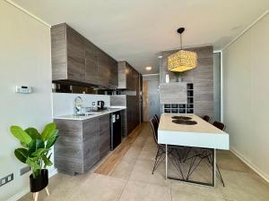 uma cozinha com mesa e cadeiras em uma sala em Maravilhoso Apartamento à beira-mar em Reñaca em Viña del Mar