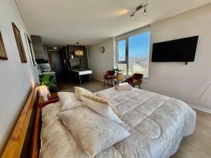 um quarto com uma cama grande e um sofá em Maravilhoso Apartamento à beira-mar em Reñaca em Viña del Mar