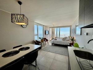 uma cozinha e sala de estar com uma cama e uma sala de jantar em Maravilhoso Apartamento à beira-mar em Reñaca em Viña del Mar mais 16 fotografias